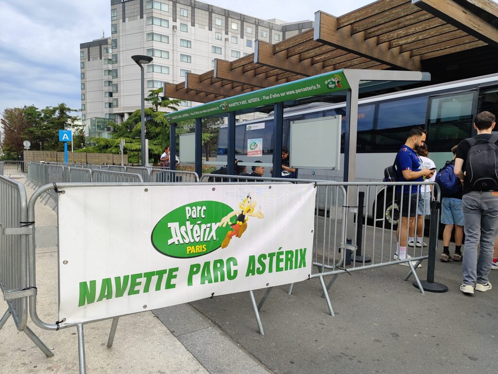 Cartel "navette Parc Astérix" en la estación Roissypole, aeropuerto de Charles de Gaulle, Francia.