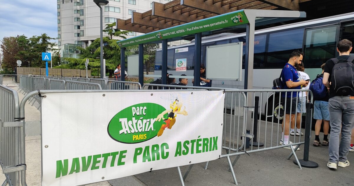 Cartel "navette Parc Astérix" en la estación Roissypole, aeropuerto de Charles de Gaulle, Francia.